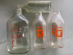 Three milk bottles and advertising medicine bottle