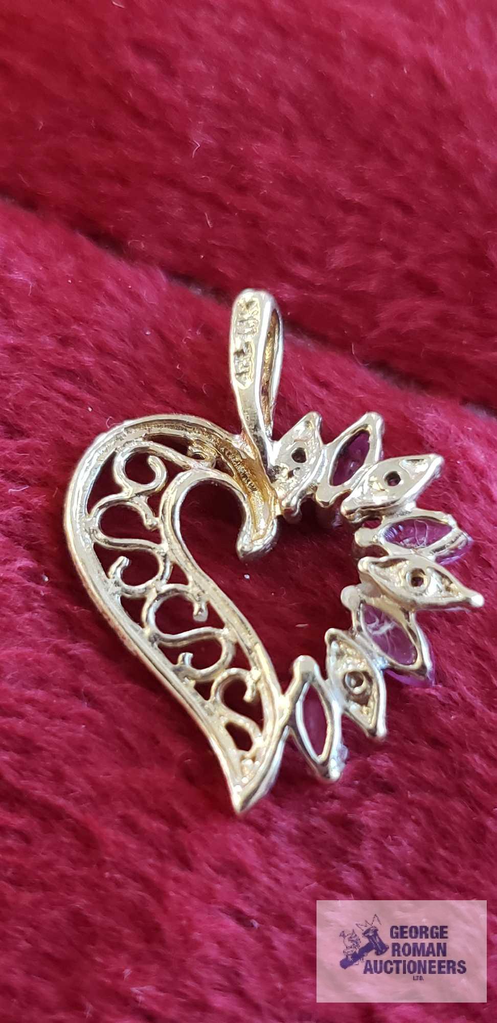 Gold colored heart-shaped pendant with clear and pinkish purple gemstones, marked 10K, approximate