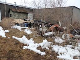Misc scrap iron and parts, located around the exterior of building, also in