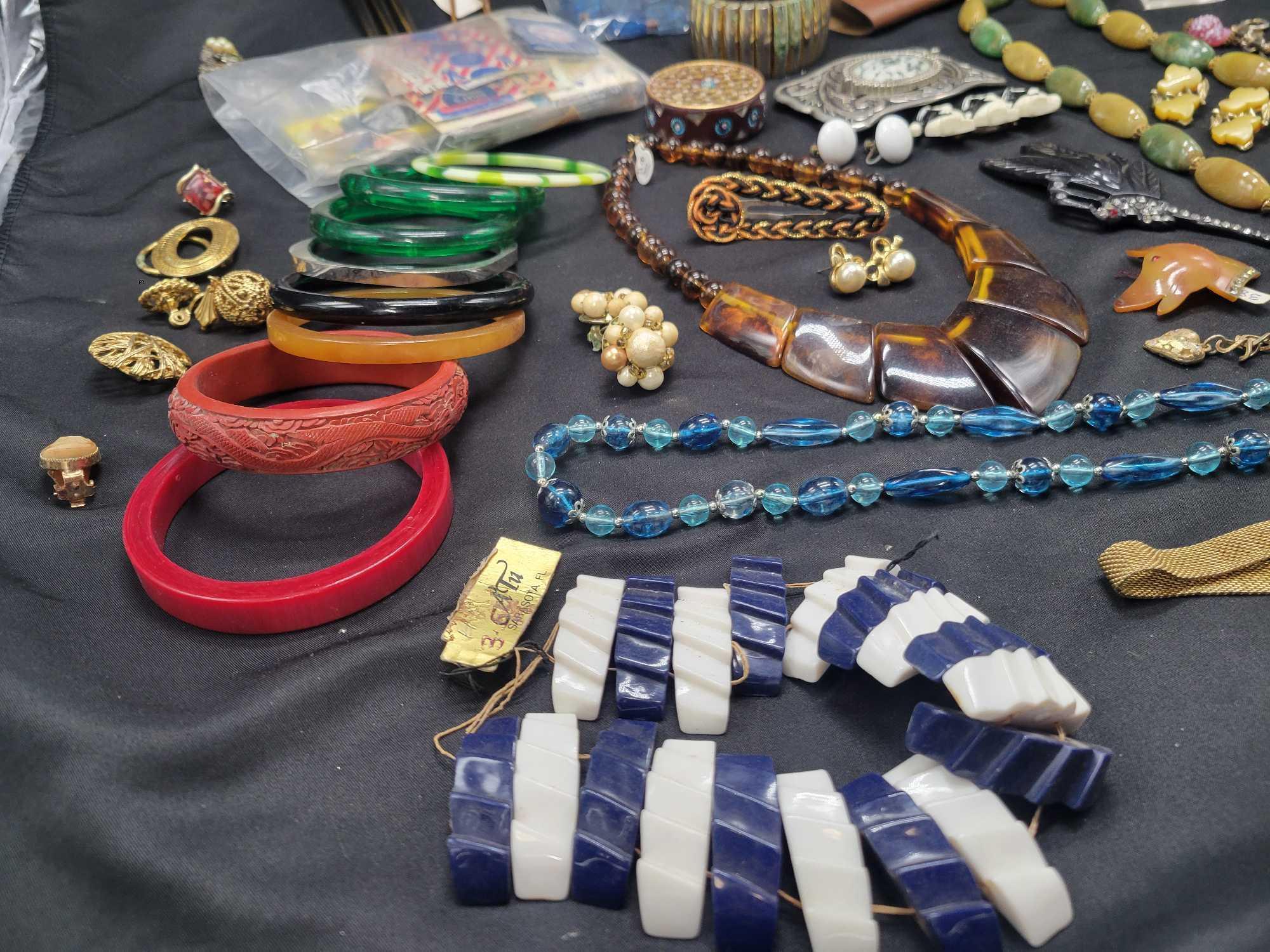Lot of plastic bangles, chinky tiger eyes necklace, celluloid hair combs brooches and more