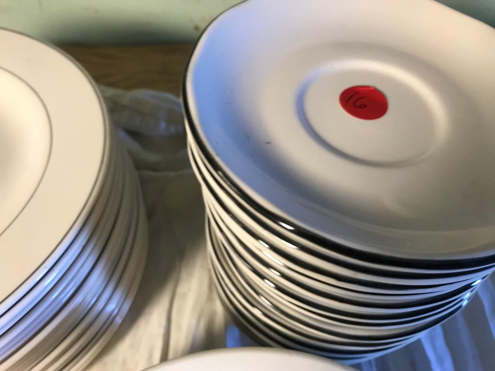 Plates and saucers with busboy tub, 16 saucers and 25 plates total