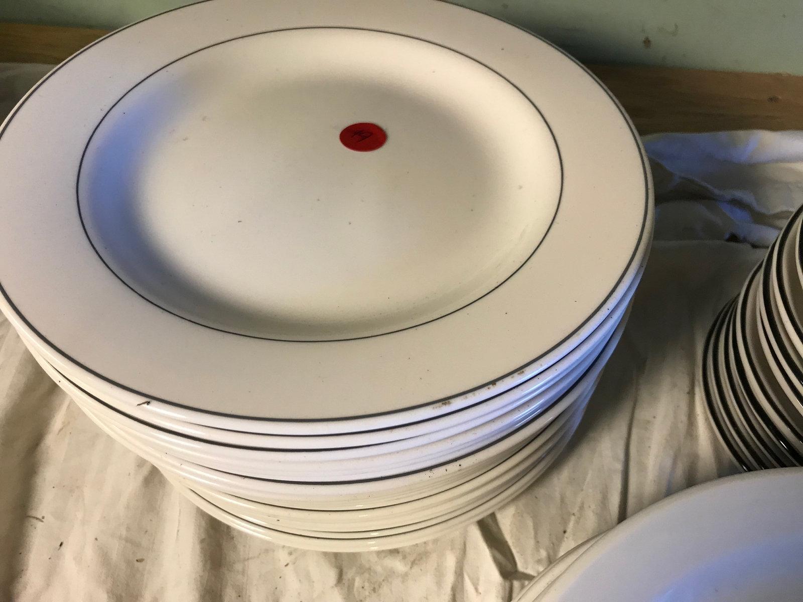 Plates and saucers with busboy tub, 16 saucers and 25 plates total
