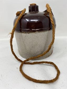 Antique brown and white crock jug with a rope handle