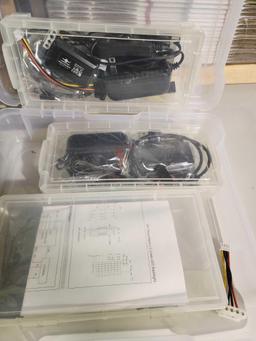Two plastic boxes. One with electronic testers, and one with DYMO label maker and label tape.