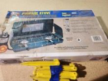 One Century two burner propane camping stove and twelve yellow plastic tent stakes. Used.