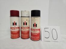 three cans of Ih spray paint red white and teal