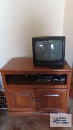 Small Silvania television with oak finish flat screen TV stand