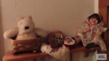 Shelf of assorted items. Baby doll, decorated boxes, teddy bear