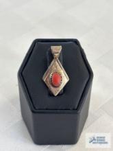 Silver colored with orange stone pendant, marked Sterling
