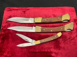 Trio of Three Folding Knives, in the style of classic Buck knives, Wood & Brass