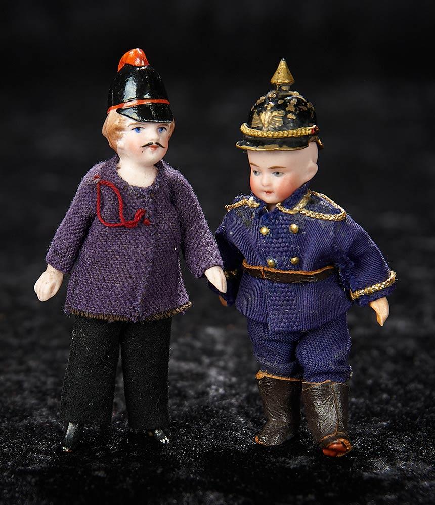Two German All-Bisque Miniature Dolls in Uniforms 300/500
