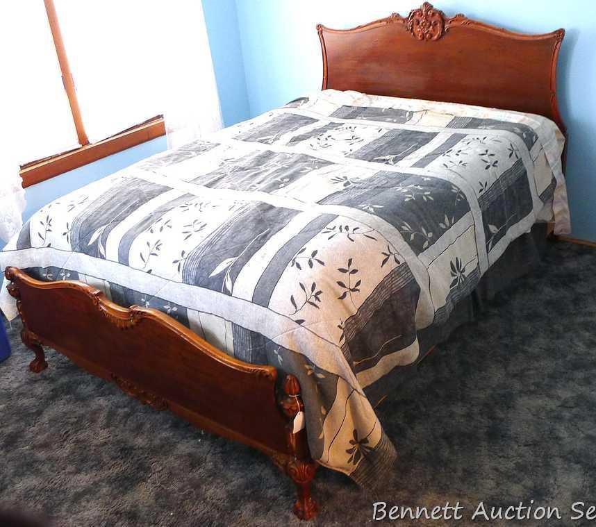 Antique bed headboard and footboard with scroll accents and claw feet. There are side boards but