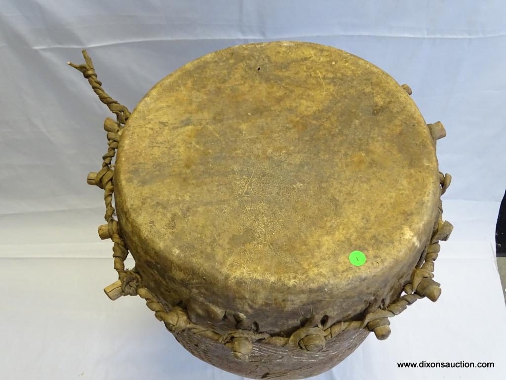 DRUM, BADIMA BUNTIBE, CIRCULAR HOLLOWED OUT HARD WOOD PEDESTAL DRUM WITH THE TOP END IMPALED WITH