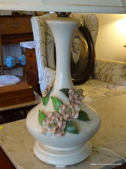 (LR) CERAMIC VASE SHAPED TABLE LAMP; WHITE VASE SHAPED TABLE LAMP WITH PINK ROSES AROUND THE SIDES.