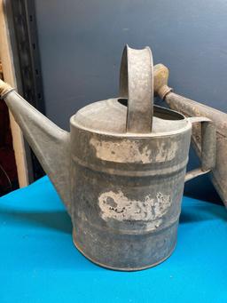 3 galvanized watering cans and a fuel can