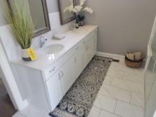 Contents of bathroon decor, rug, artificial plants, towels, basket and soap dispenser