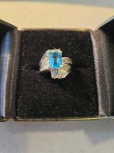 Lady's 14k white gold ring with emerald cut blue topaz